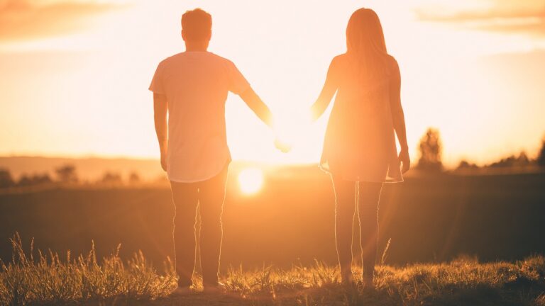 uomo e donna mano nella mano al tramonto