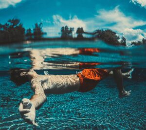 uomo galleggia in piscina