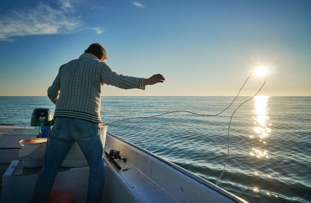 pescatore getta la rete in mare