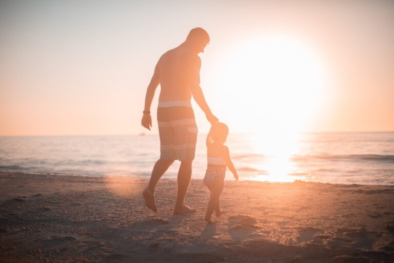 papà tieni bimbo per mano sulla spiaggia